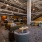 a clubhouse room with seating, tables and a staircase