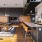 a clubhouse kitchen with a wood floor, a bar, chairs and a tv